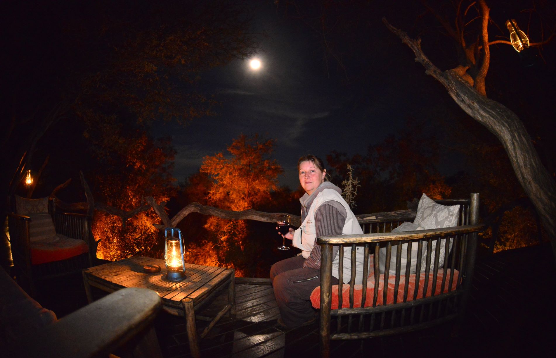 Jen having a glass of red wine on the deck before dinner at Makanyane Safari Lodge