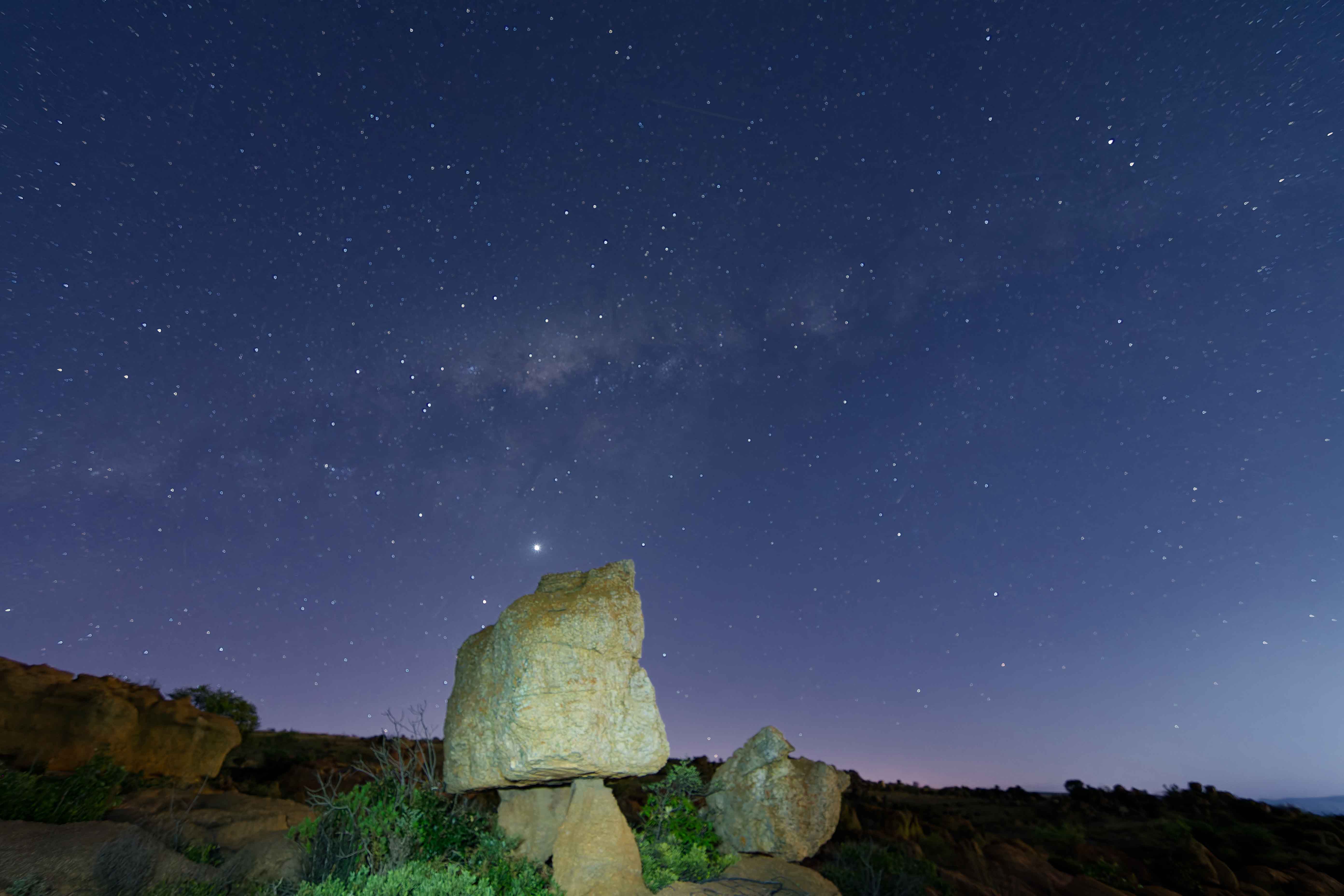 Mushroom rock formation under stars