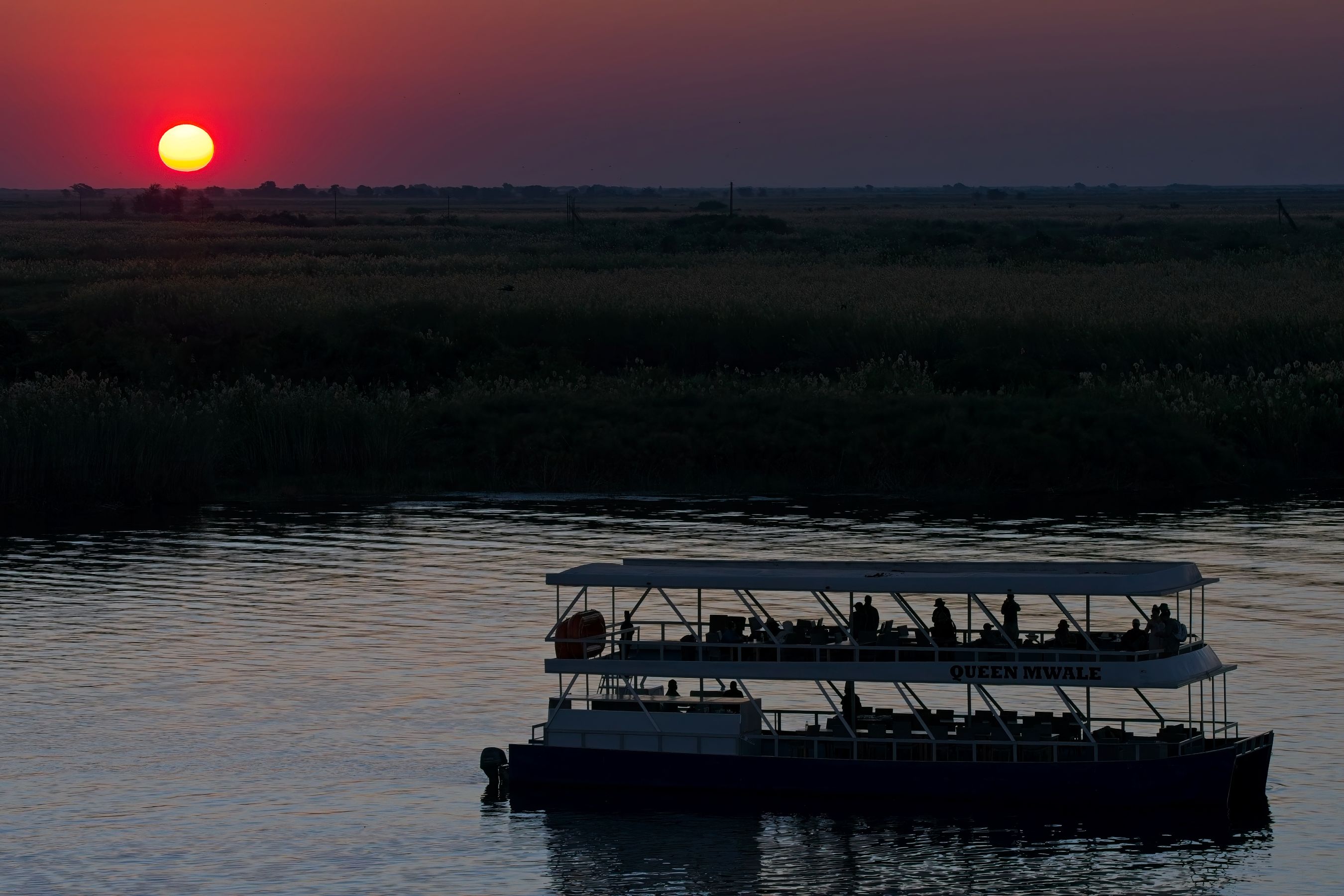 The cruise boat Queen on the Chobe River at sunset