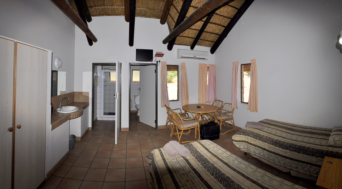 Bedroom and bathroom in chalet at Twee Rivieren camp